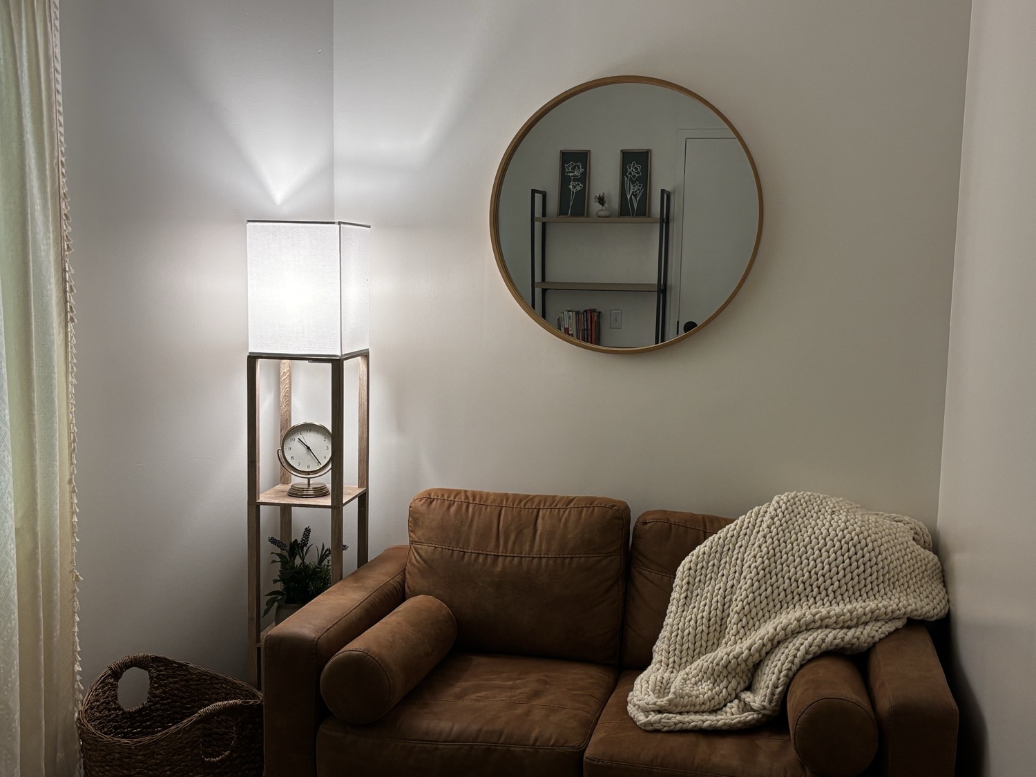 A counseling room at REWind Counseling, with a lamp, mirror and leather loveseat